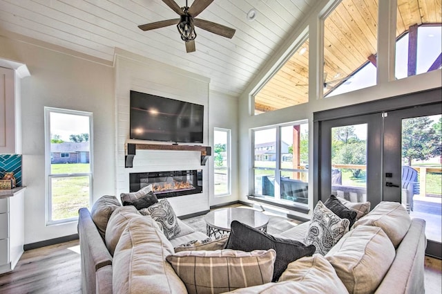 living room featuring plenty of natural light, light hardwood / wood-style flooring, high vaulted ceiling, and wood ceiling