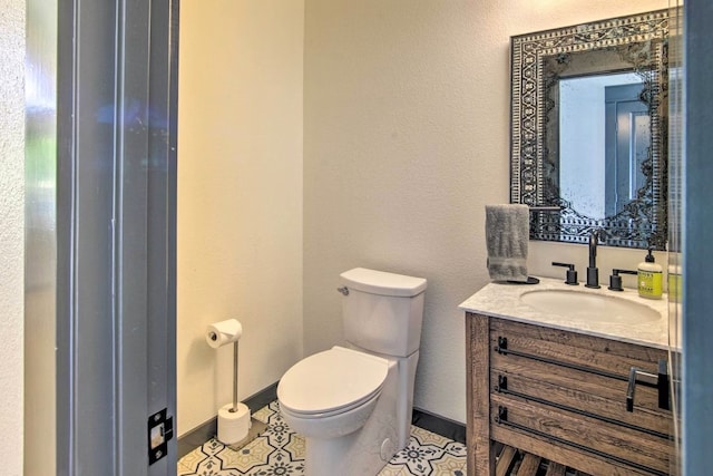 bathroom with tile patterned flooring, vanity, and toilet