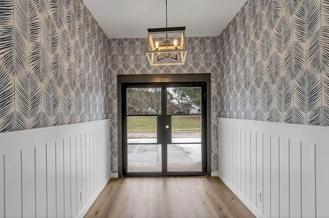 doorway featuring an inviting chandelier, radiator heating unit, wood-type flooring, and french doors