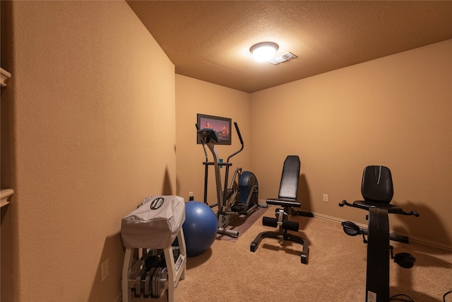 workout area featuring carpet flooring and a textured ceiling