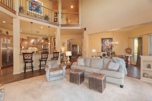 living room with a high ceiling, dark hardwood / wood-style flooring, and a notable chandelier