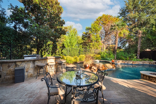 view of patio with a fenced in pool, an outdoor bar, and exterior kitchen