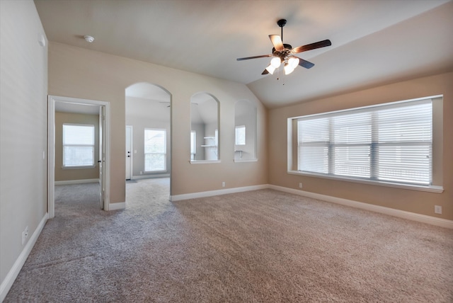 carpeted spare room with vaulted ceiling and ceiling fan