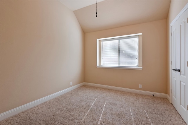 unfurnished room featuring carpet and lofted ceiling