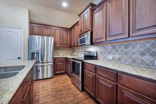 kitchen featuring decorative backsplash, appliances with stainless steel finishes, sink, and light stone counters