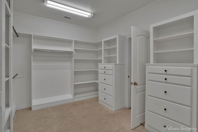 walk in closet with light carpet