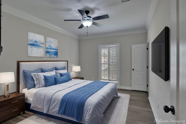 bedroom featuring hardwood / wood-style flooring, ceiling fan, and crown molding