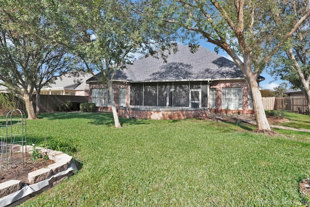 back of house with a lawn and a sunroom