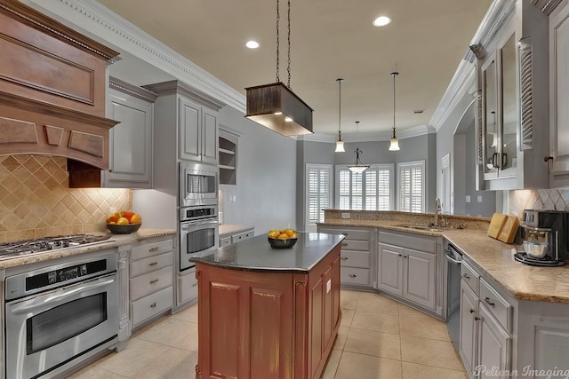 kitchen featuring sink, crown molding, hanging light fixtures, a kitchen island, and kitchen peninsula