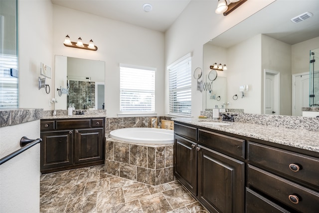 bathroom featuring vanity, independent shower and bath, and plenty of natural light