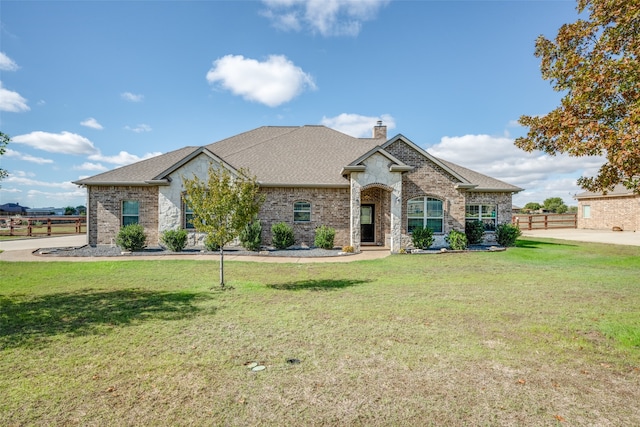 french country inspired facade featuring a front yard