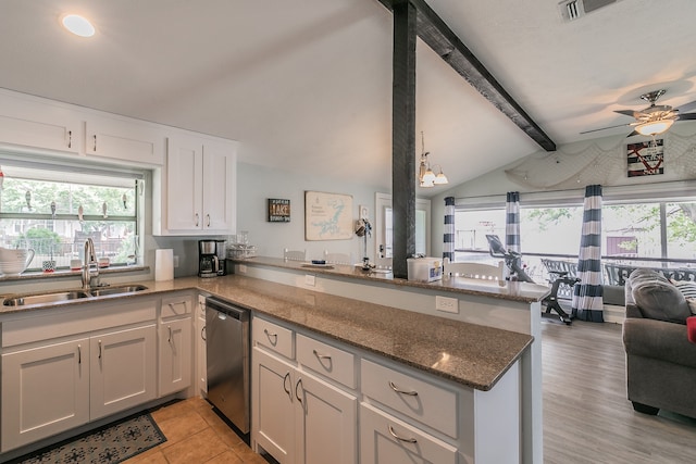 kitchen with a wealth of natural light, sink, white cabinets, stainless steel dishwasher, and kitchen peninsula