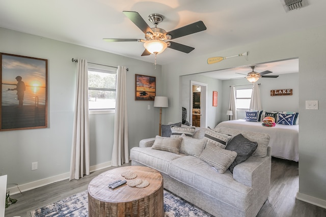 bedroom with ceiling fan, multiple windows, and dark hardwood / wood-style flooring