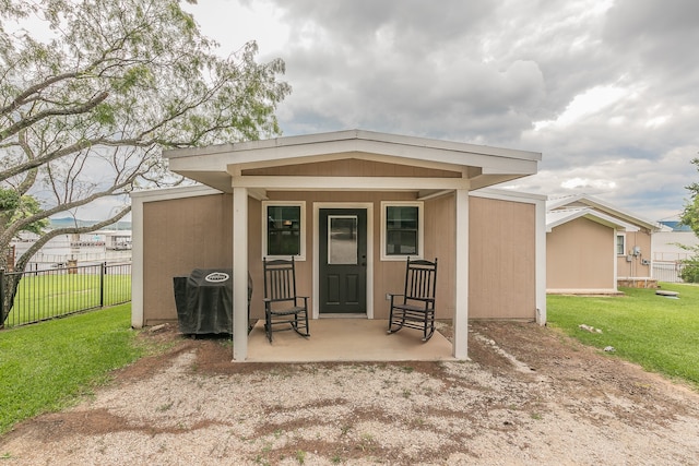 view of outdoor structure with a yard and a porch