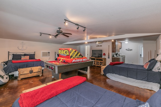 bedroom with track lighting, dark hardwood / wood-style floors, a wall mounted air conditioner, lofted ceiling, and ceiling fan