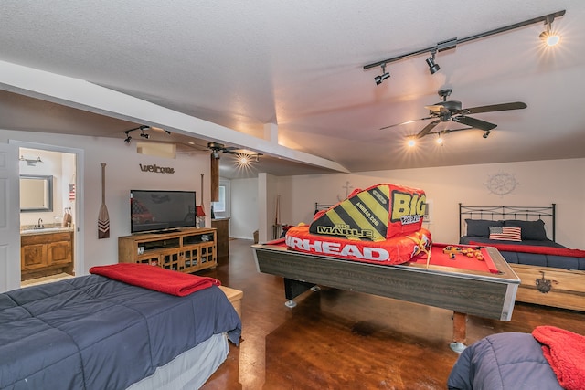 bedroom with ensuite bath, track lighting, a textured ceiling, sink, and ceiling fan