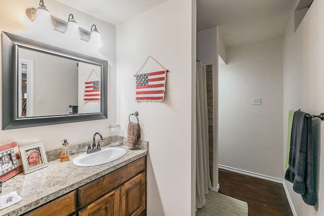 bathroom with a shower with curtain, wood-type flooring, and vanity