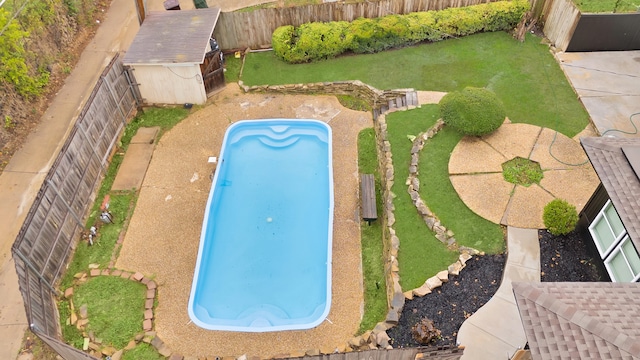 view of pool featuring a yard and a storage unit