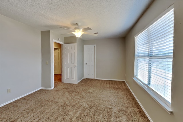 empty room featuring carpet, a textured ceiling, and ceiling fan