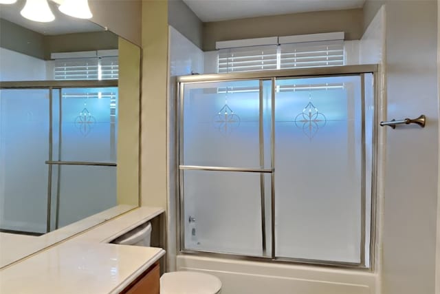 full bathroom with vanity, combined bath / shower with glass door, and toilet