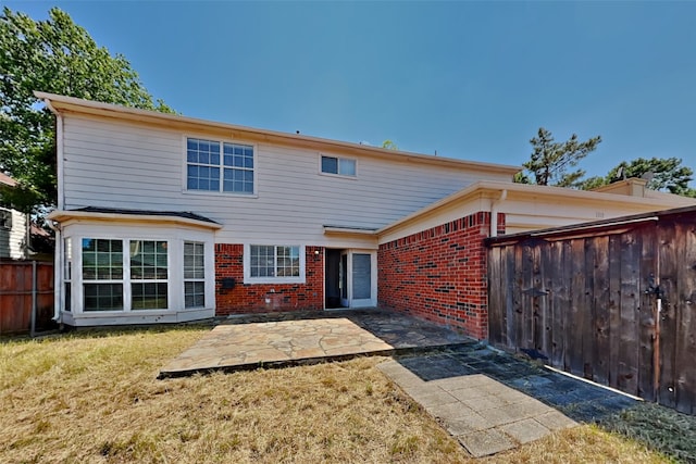 rear view of property featuring a lawn and a patio