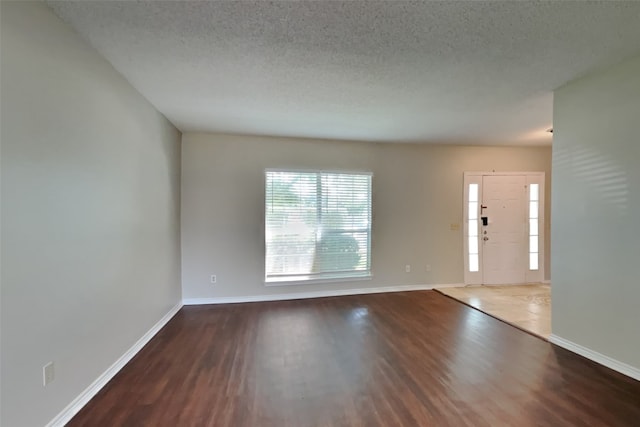 interior space featuring dark hardwood / wood-style flooring and a textured ceiling