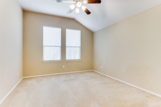 carpeted spare room featuring vaulted ceiling and ceiling fan