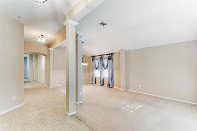 carpeted spare room with decorative columns