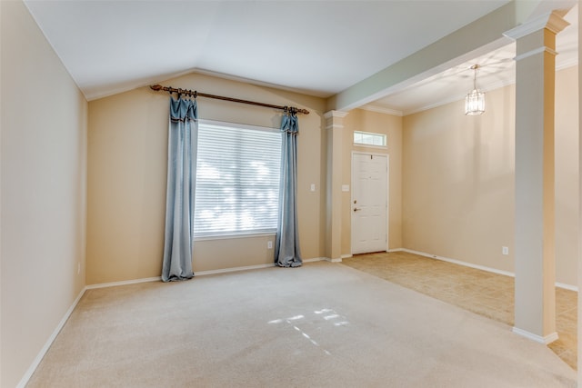 spare room with carpet flooring, ornamental molding, decorative columns, and lofted ceiling