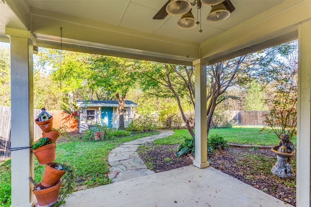 view of patio featuring ceiling fan and an outbuilding