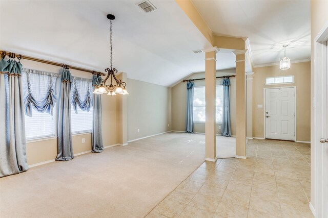 interior space with lofted ceiling, light carpet, an inviting chandelier, ornate columns, and ornamental molding