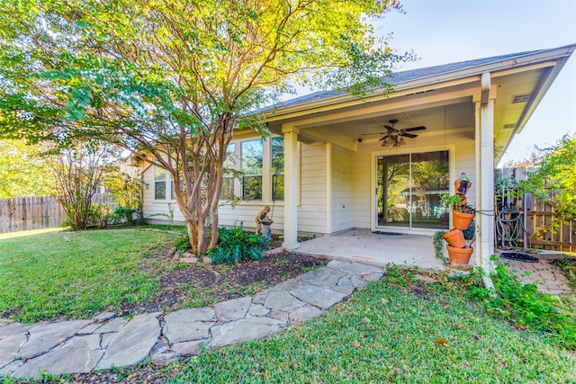 doorway to property featuring a lawn, ceiling fan, and a patio