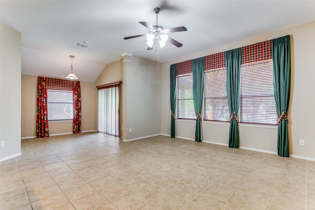 tiled spare room featuring ceiling fan, decorative columns, and vaulted ceiling