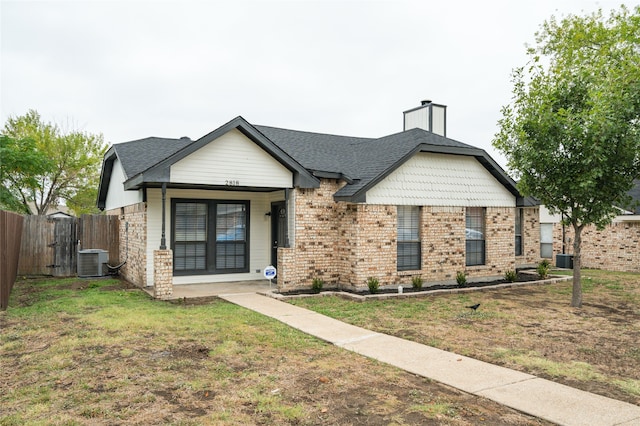 view of front of home with cooling unit and a front lawn