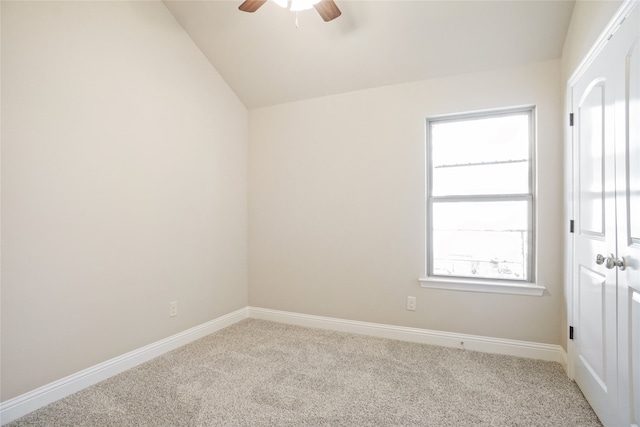 carpeted spare room with lofted ceiling and ceiling fan