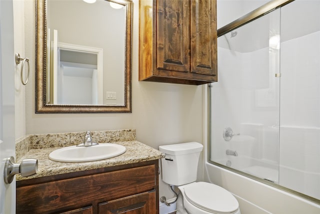 full bathroom featuring bath / shower combo with glass door, vanity, and toilet