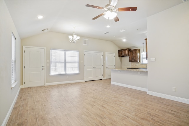 unfurnished living room with light hardwood / wood-style floors, ceiling fan with notable chandelier, and vaulted ceiling