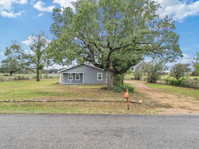 view of front of property featuring a rural view and a front lawn