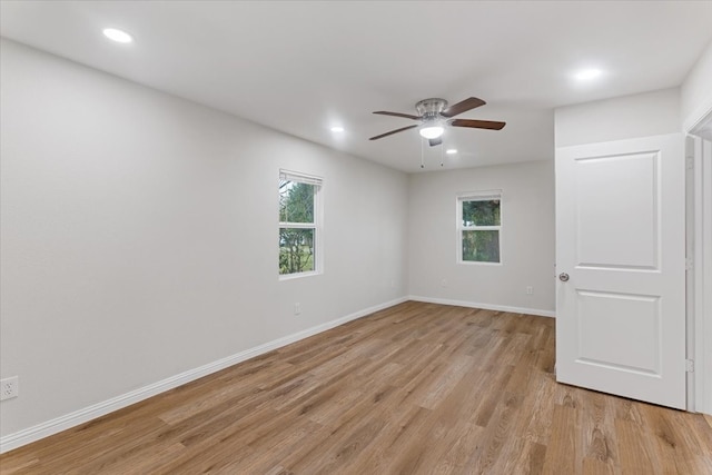 unfurnished room with a wealth of natural light, light hardwood / wood-style floors, and ceiling fan