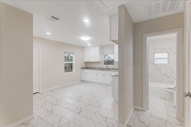 kitchen featuring white cabinetry and light stone counters