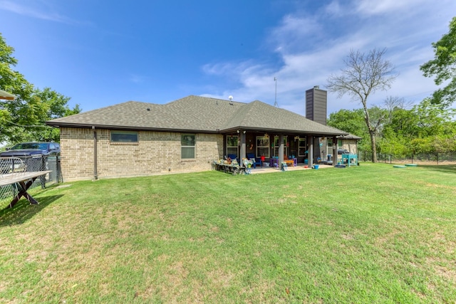 back of house with a lawn and a patio area