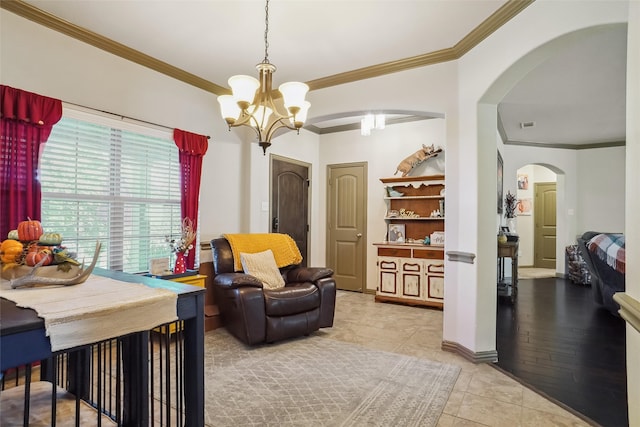 sitting room with light wood-type flooring, ornamental molding, and a notable chandelier