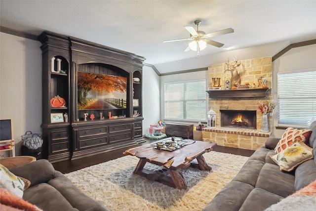 living room featuring a fireplace, ceiling fan, dark hardwood / wood-style flooring, and crown molding