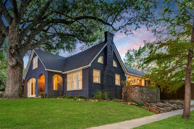 english style home with a lawn