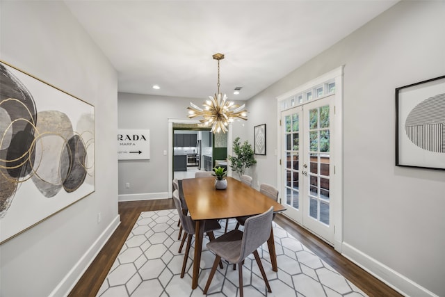 dining space featuring french doors, hardwood / wood-style flooring, and a notable chandelier