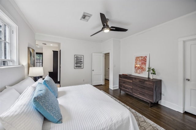 bedroom featuring ornamental molding, multiple windows, dark hardwood / wood-style flooring, and ceiling fan