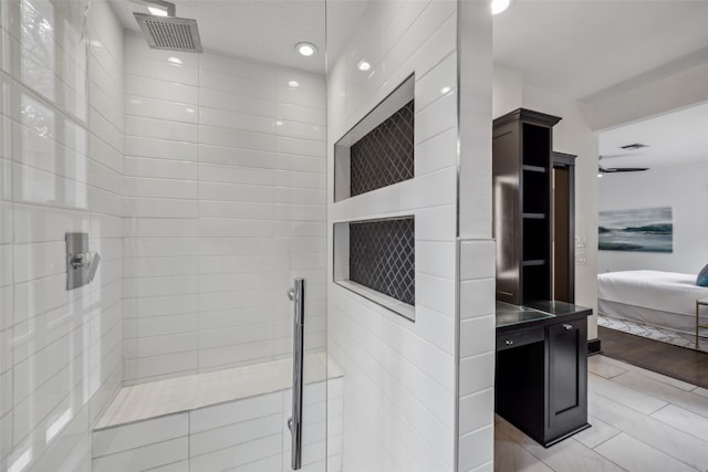 bathroom with hardwood / wood-style floors and a tile shower