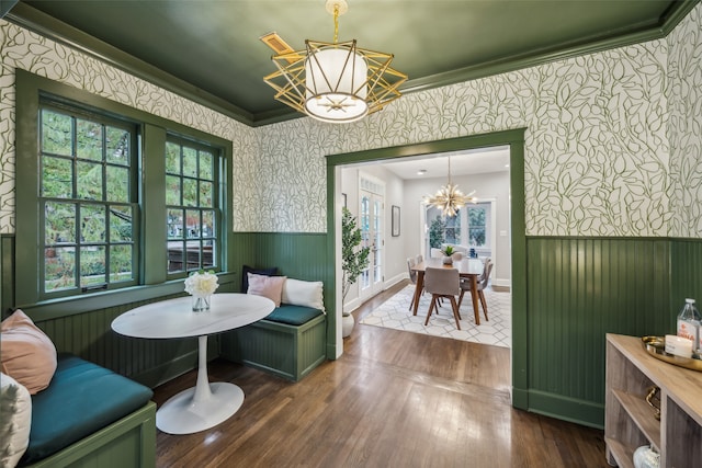 dining space featuring breakfast area, crown molding, dark hardwood / wood-style flooring, and a notable chandelier