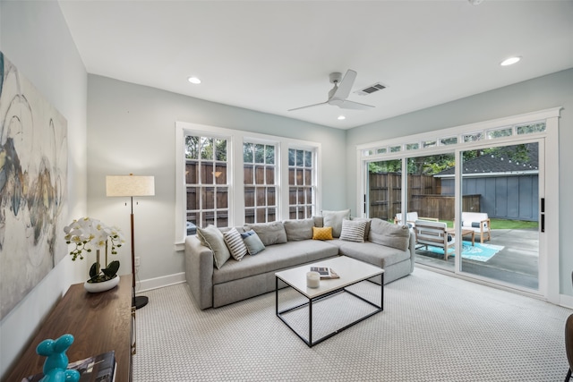 carpeted living room with ceiling fan