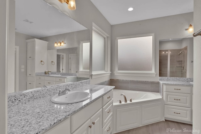 bathroom with vanity and independent shower and bath